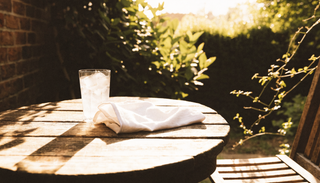 Iced water and a cotton flannel on a garden table in strong summer sun